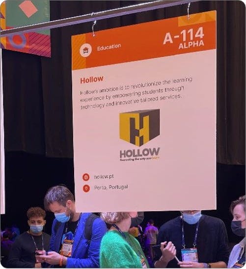 A big card with Hollow's info and people in the background of the photo